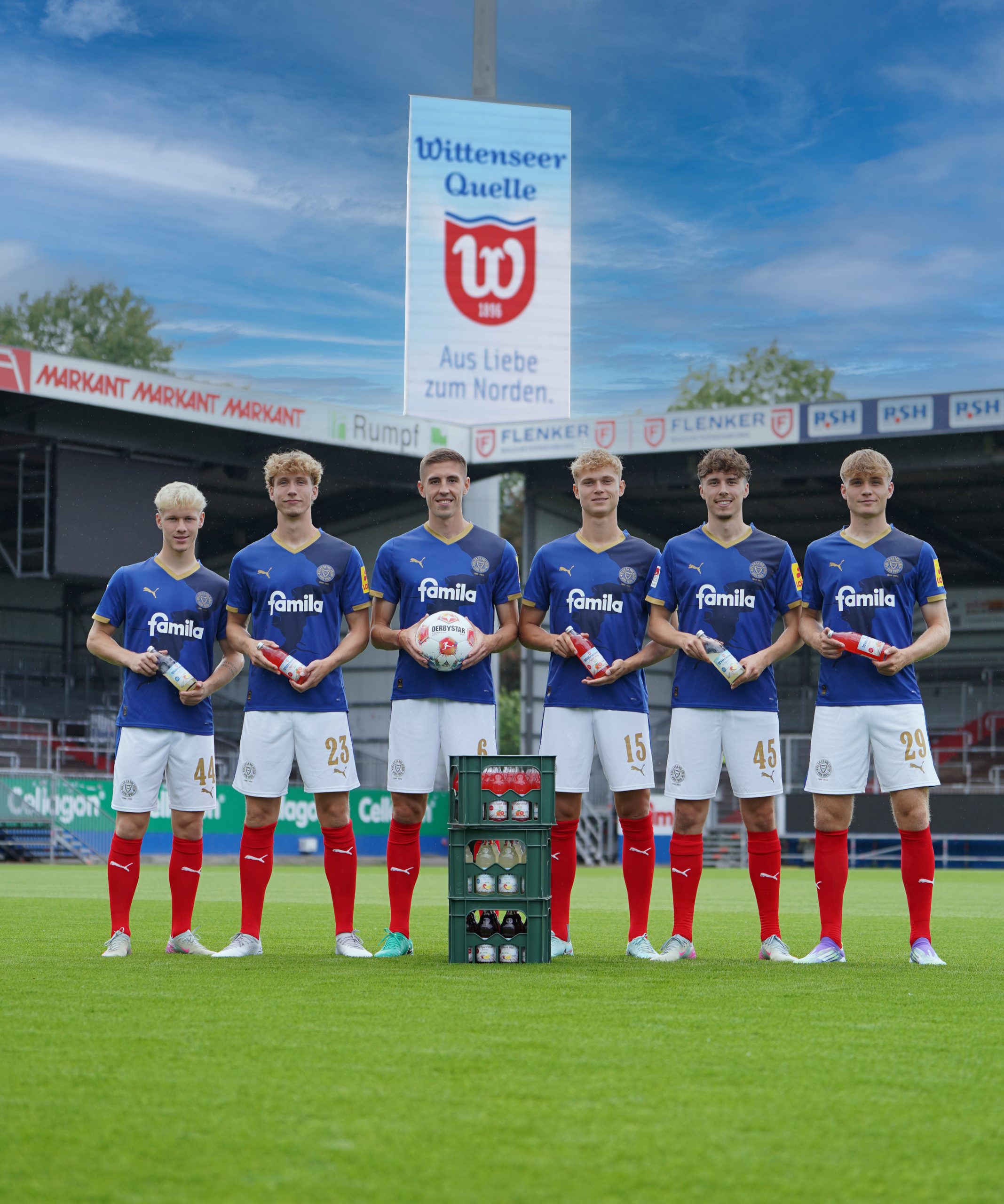 Holstein Kiel Spieler im Stadion mit Wittenseer IsoSpor Vital Glas-Mehrwegflaschen in 0,5l. Im Hintergrund das Werbebanner der Wittenseer Quelle.
