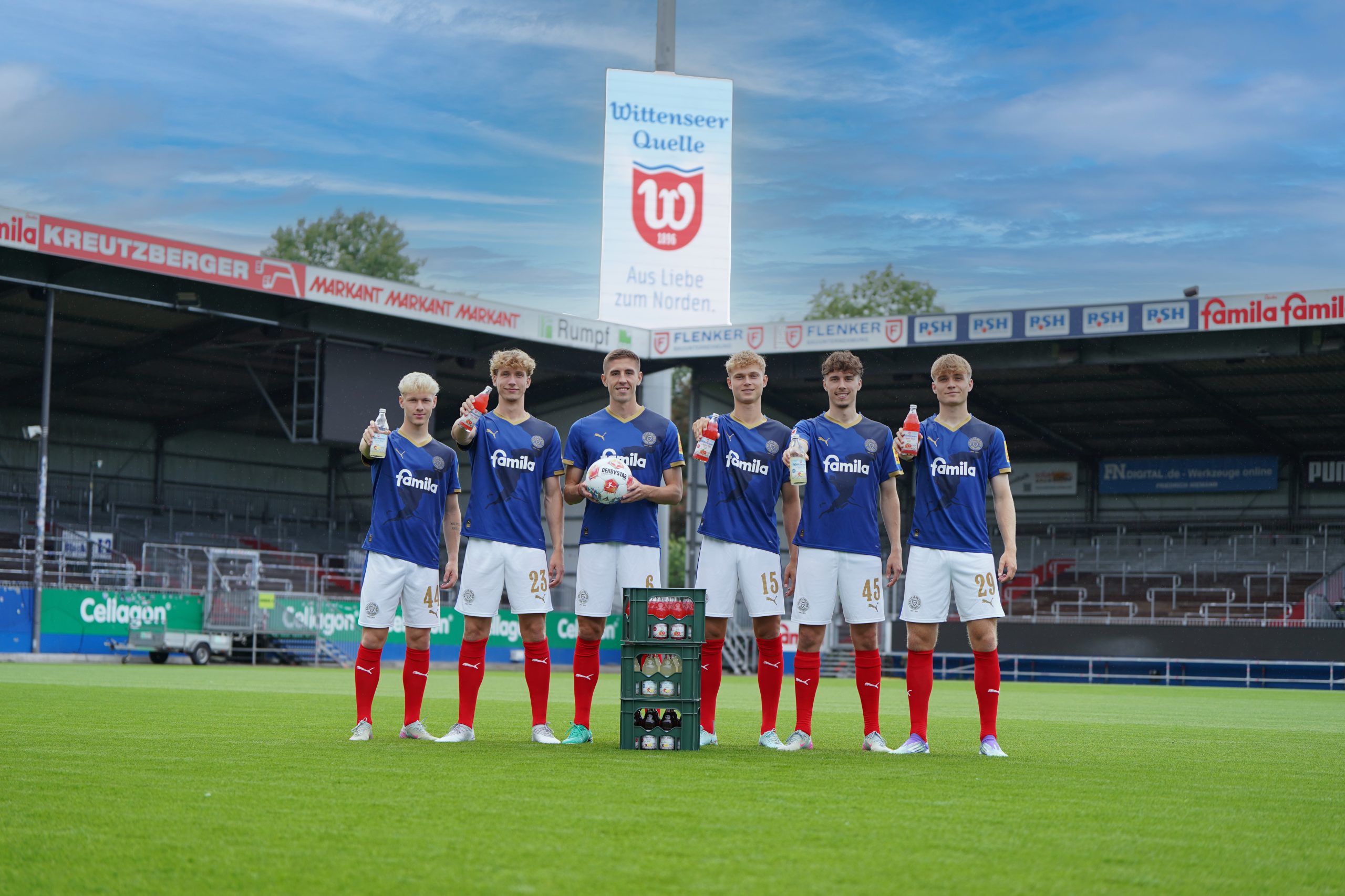 Holstein Kiel Spieler im Stadion mit Wittenseer IsoSpor Vital Glas-Mehrwegflaschen in 0,5l. Im Hintergrund das Werbebanner der Wittenseer Quelle.