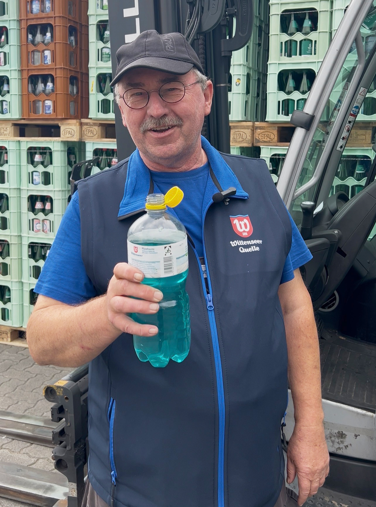 Mitarbeiter mit IsoSport Vital Blaubeer-Zitrone-Getränk.